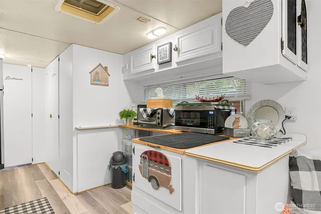 a utility room with stainless steel appliances granite countertop a sink and a refrigerator