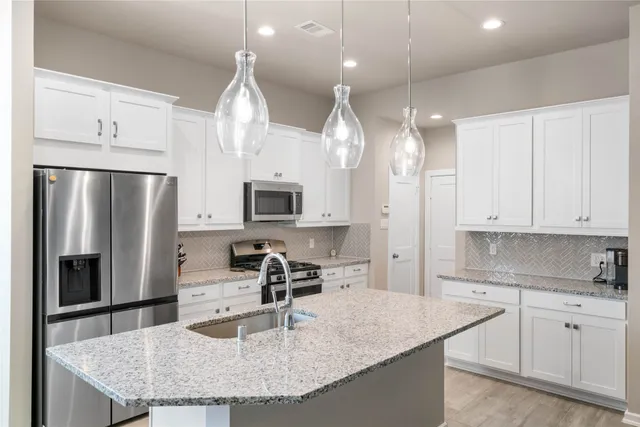 a kitchen with stainless steel appliances granite countertop a sink refrigerator and microwave