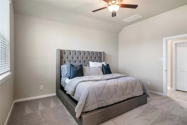 a bedroom with a bed and ceiling fan
