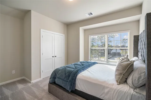 a bedroom with a bed and a large window