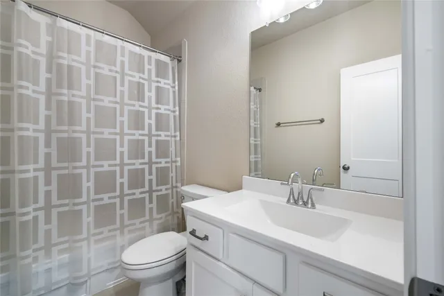 a bathroom with a sink toilet vanity and shower