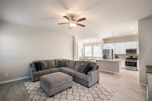 a living room with stainless steel appliances kitchen island granite countertop furniture and a fireplace
