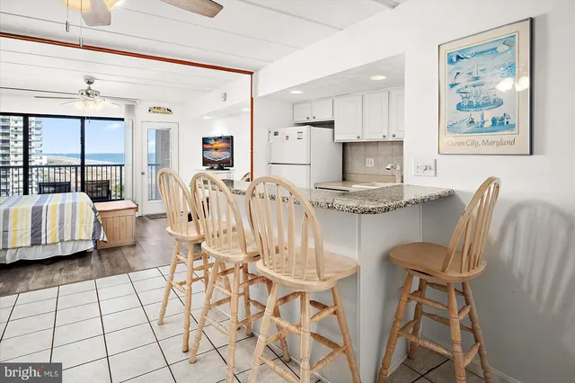 a living room with furniture and a refrigerator