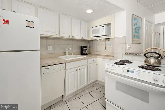 a living room with a couch and a view of kitchen