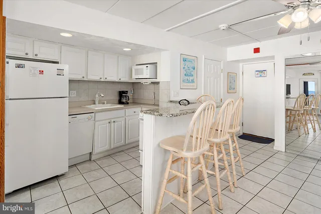 a living room with furniture a chandelier and a dining table with wooden floor