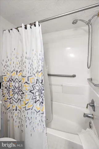 a white toilet sitting next to a shower curtain
