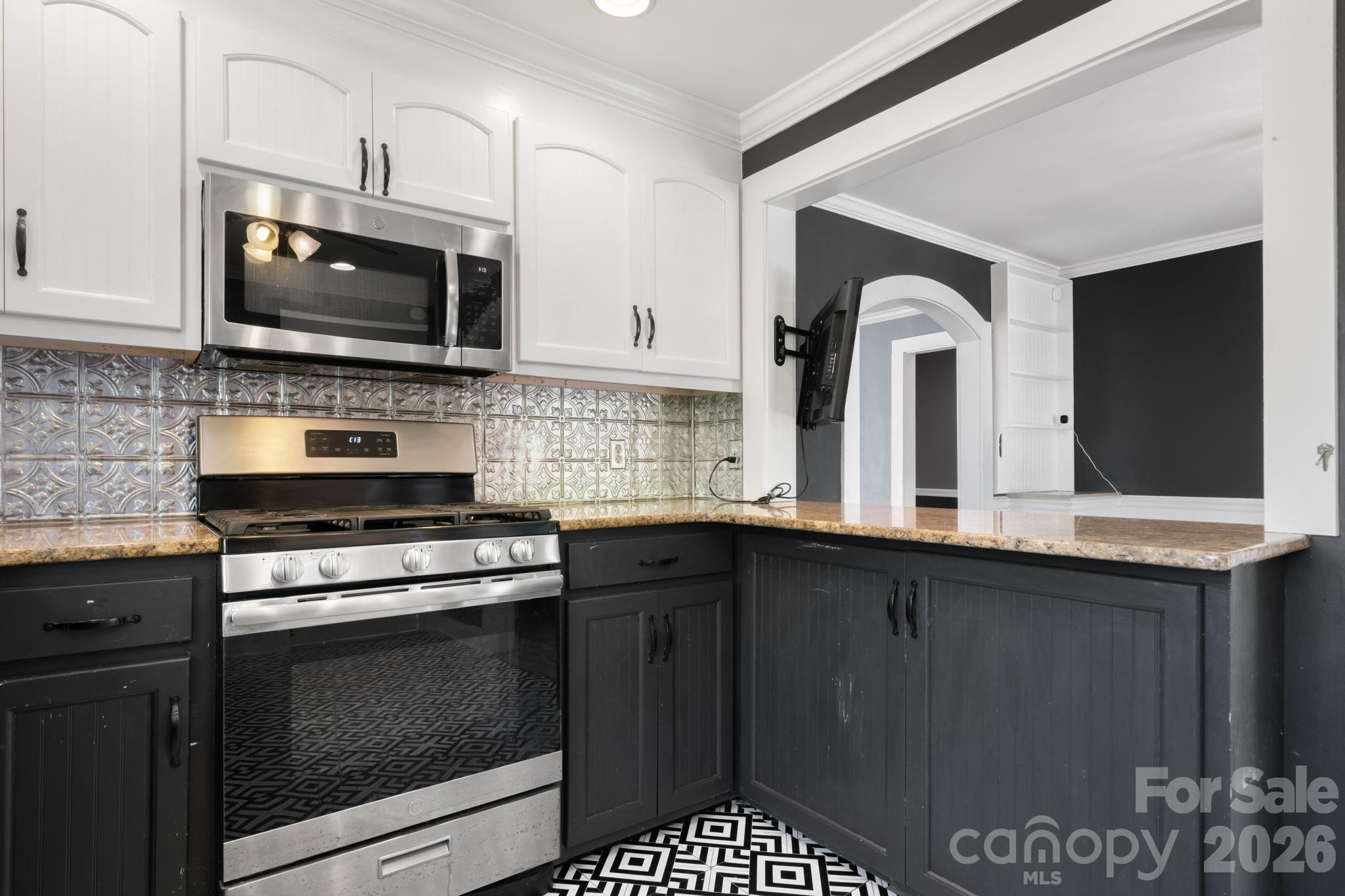 715 Main Street Hudson, NC 28638 - Photo 8 of 26 a kitchen with granite countertop a stove top oven microwave and cabinets