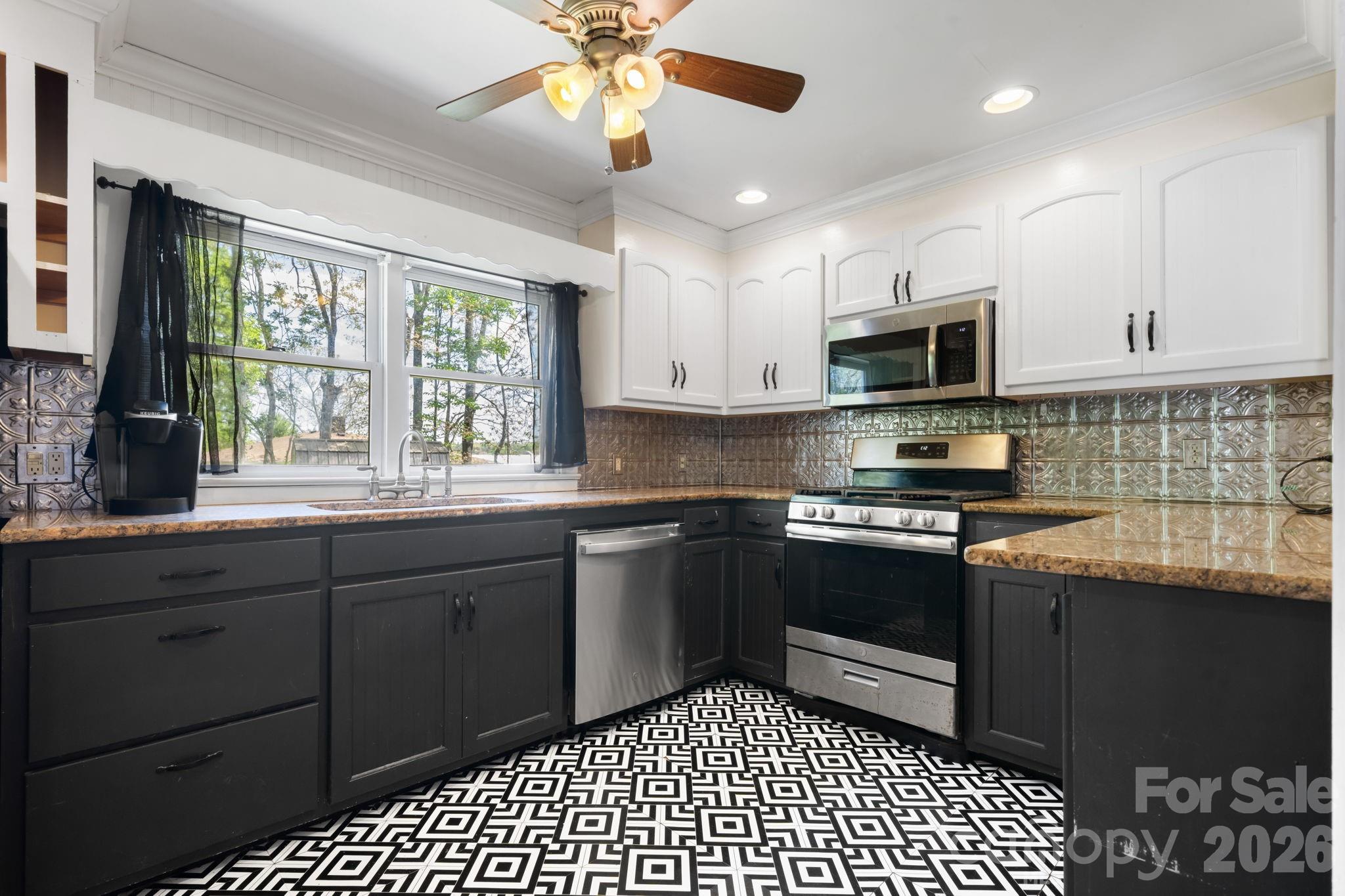 715 Main Street Hudson, NC 28638 - Photo 10 of 26 a kitchen with stainless steel appliances granite countertop a stove a sink and a microwave