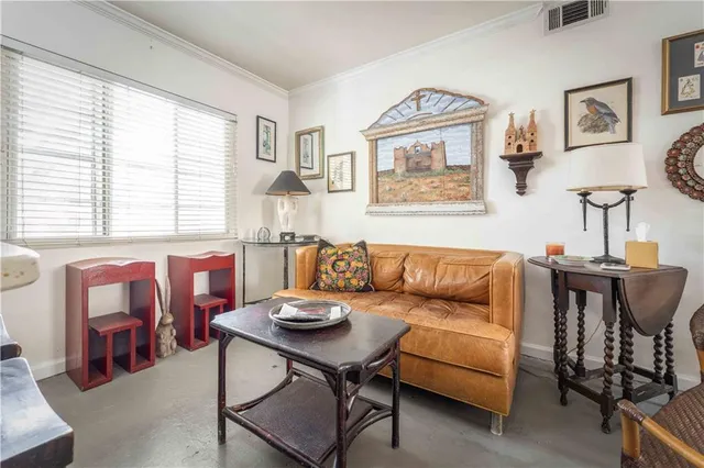 a living room with furniture and paintings on the wall