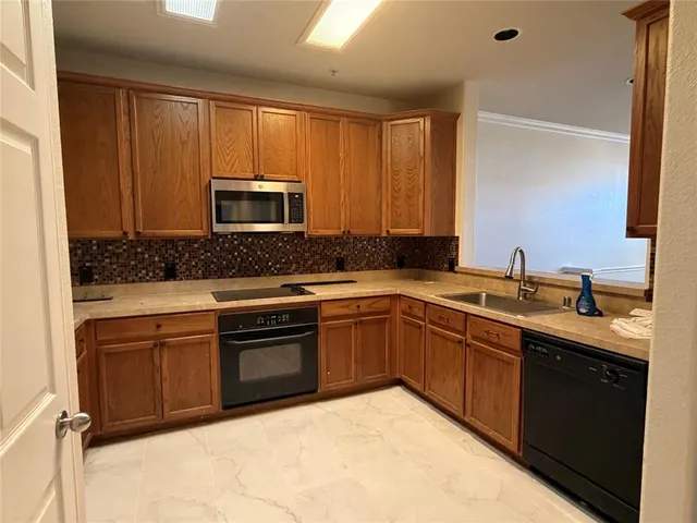 a kitchen with stainless steel appliances granite countertop a sink and a stove top oven with granite countertops
