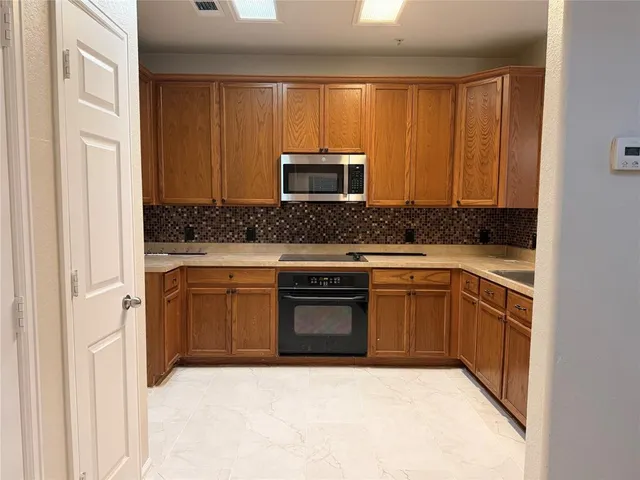 a kitchen with stainless steel appliances granite countertop a stove a sink and a microwave