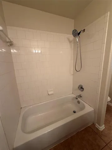 a bathroom with a bath tub with a shower