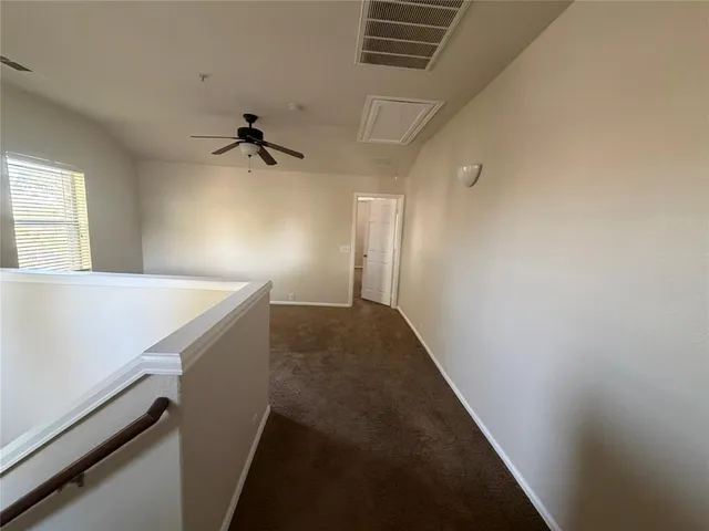 a view of a hallway with a ceiling fan