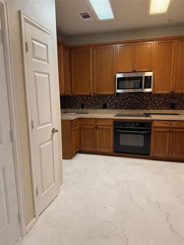 a kitchen with stainless steel appliances granite countertop a refrigerator and microwave