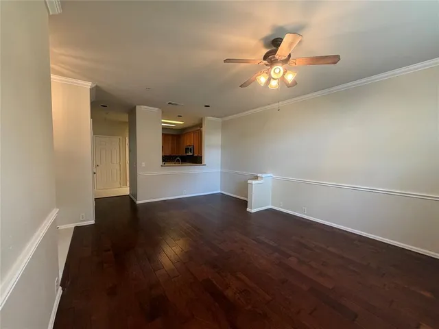 a view of a livingroom with wooden floor and a ceiling fan