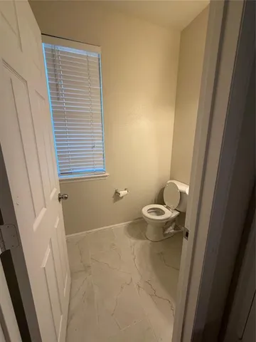 a bathroom with a toilet and a window