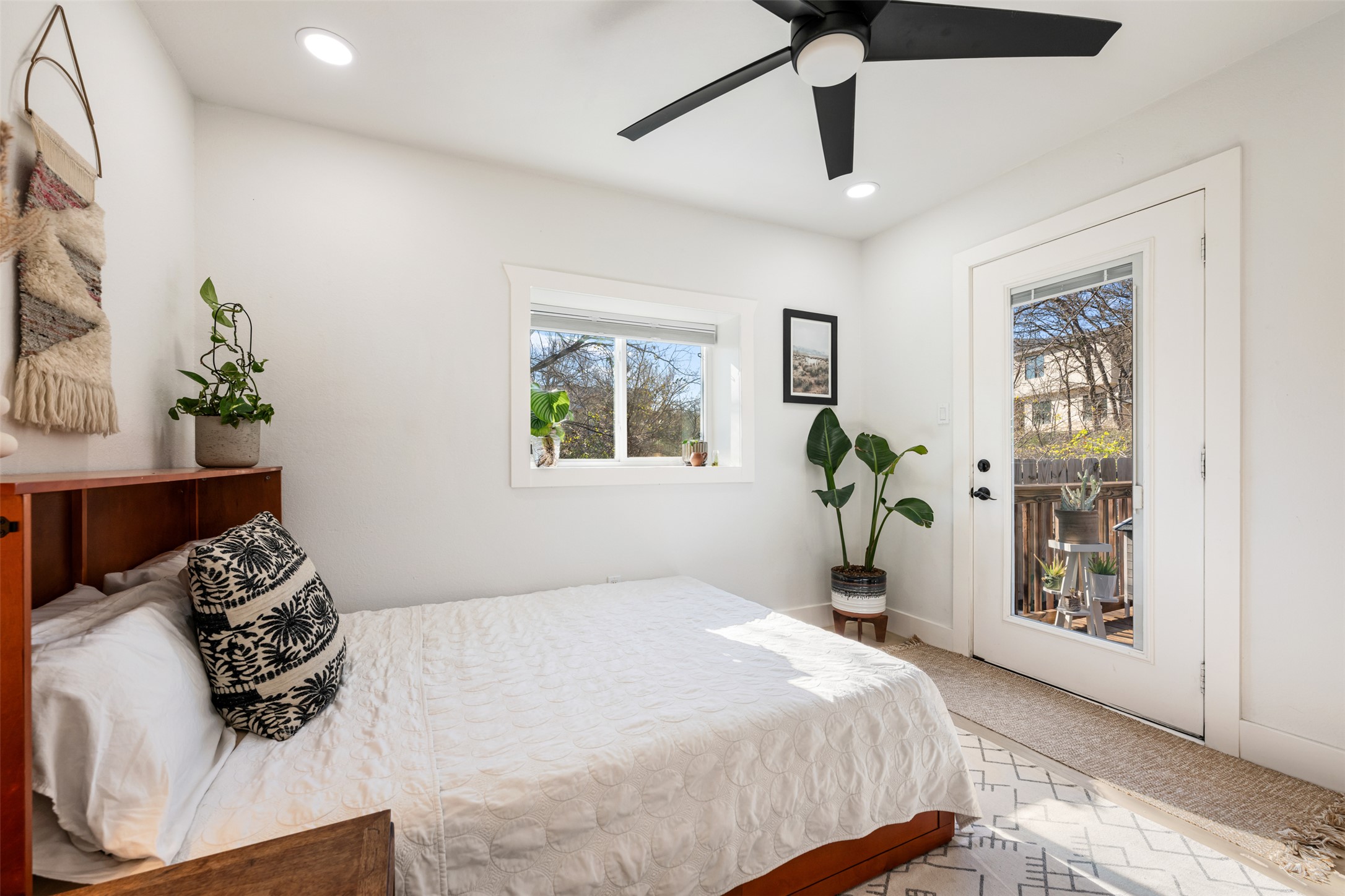1616 Webberville Road, Unit A Austin, TX 78721 - Photo 4 of 28 Bedroom with light colored carpet, access to outside, ceiling fan, and recessed lighting