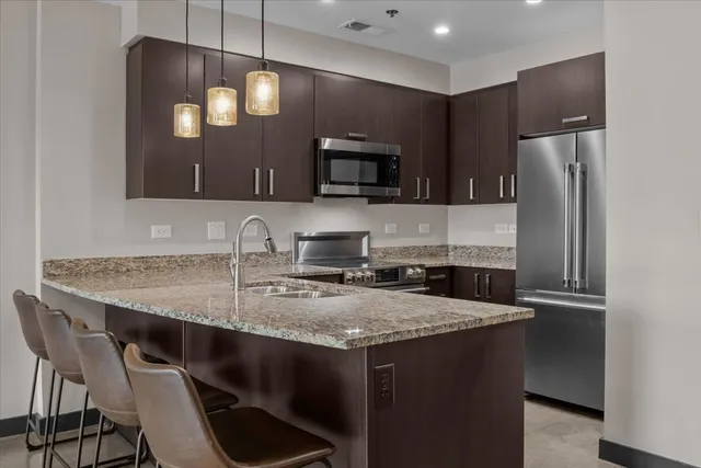 a kitchen with stainless steel appliances granite countertop a sink and a granite counter tops