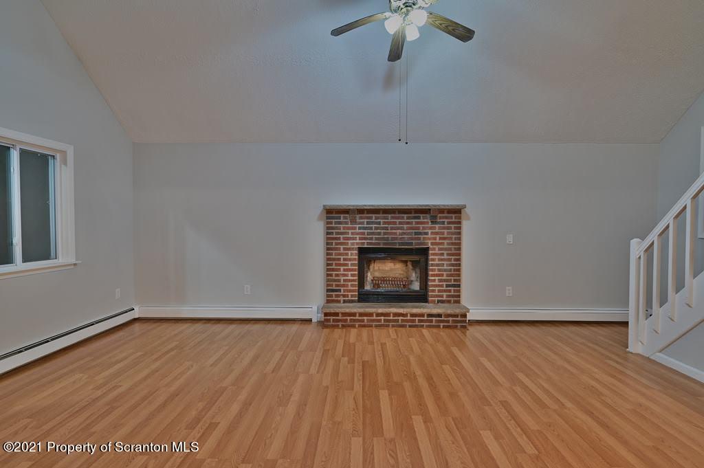 978 Goose Pond Road Lake Ariel, PA 18436 - Photo 5 of 44 an empty room with wooden floor a fireplace