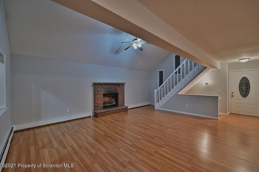 978 Goose Pond Road Lake Ariel, PA 18436 - Photo 6 of 44 a view of an empty room with wooden floor staircase and a kitchen