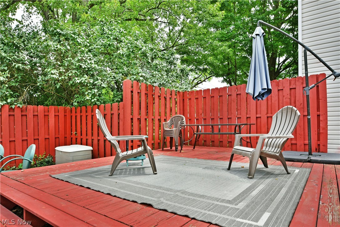 8683 King Graves Road Northeast Warren, OH 44484 - Photo 43 of 50 Spacious red-stained wood deck featuring a red picket fence and mature perimeter landscaping