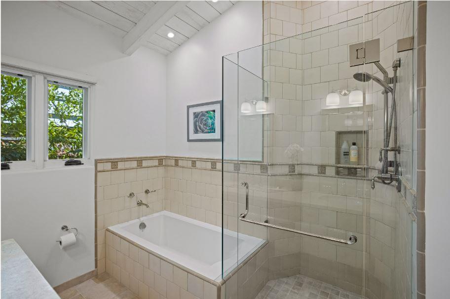 Junipero Street Carmel, CA 93921 - Photo 15 of 33 a bathroom with a tub a window and glass door shower