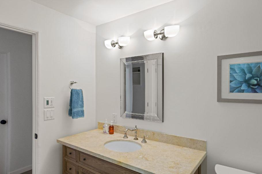 Junipero Street Carmel, CA 93921 - Photo 21 of 33 a bathroom with a granite countertop sink and a mirror