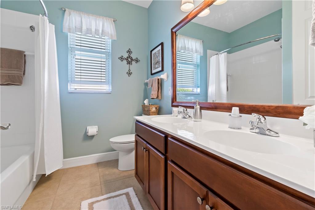 19912 Maddelena Circle Estero, FL 33967 - Photo 13 of 20 a bathroom with a granite countertop sink a toilet and a mirror