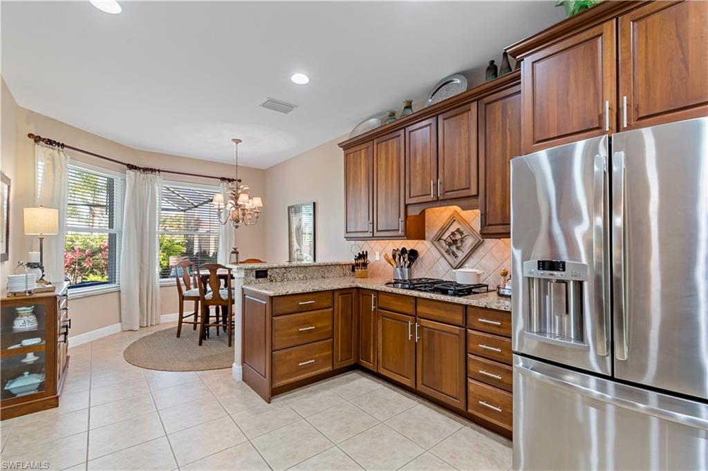 19912 Maddelena Circle Estero, FL 33967 - Photo 4 of 20 a kitchen with stainless steel appliances granite countertop a refrigerator sink and cabinets