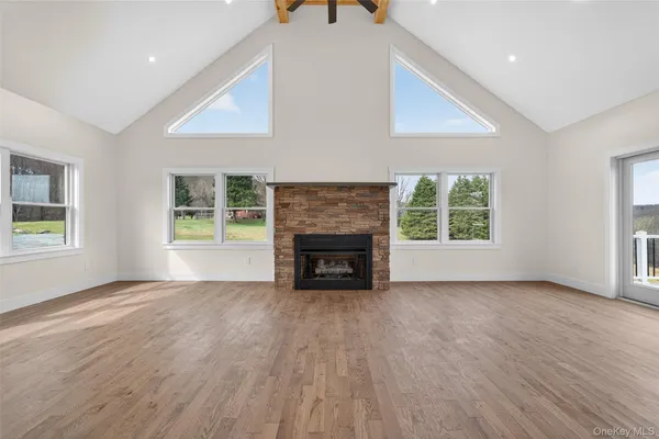 an empty room with windows and fireplace