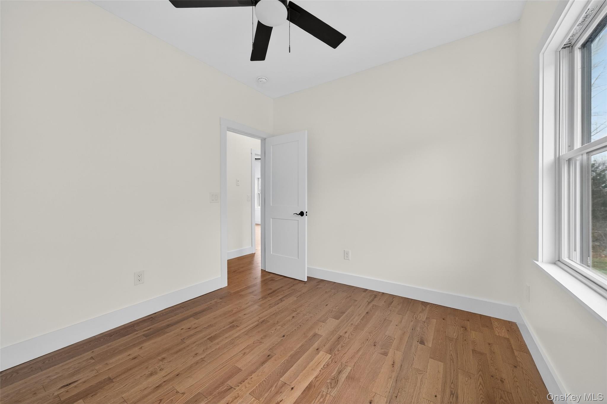 129 Nelson Road Hankins, NY 12741 - Photo 21 of 31 an empty room with wooden floor and windows