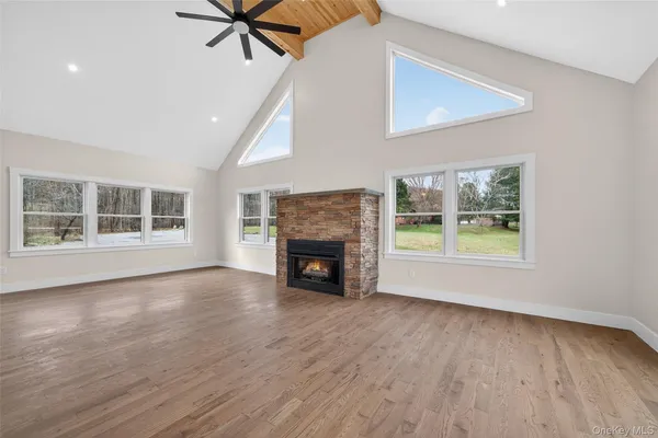 a view of an empty room with a window and fireplace