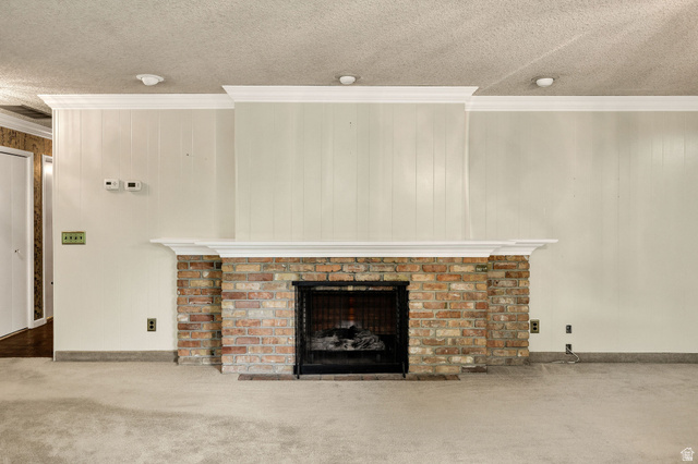 1365 Sumac Drive Logan, UT 84321 - Photo 21 of 66 Brick fireplace with a black metal screen, a white mantel, and crown molding