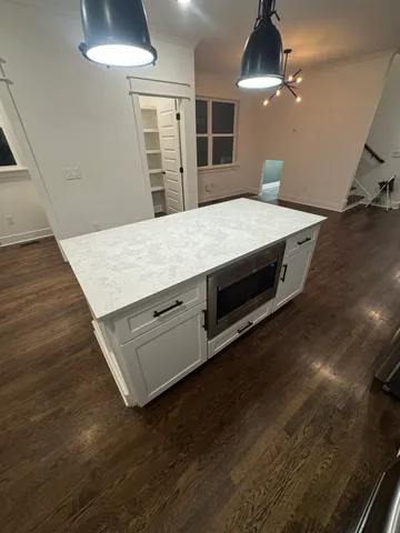 a view of an empty room with wooden floor fireplace and a window