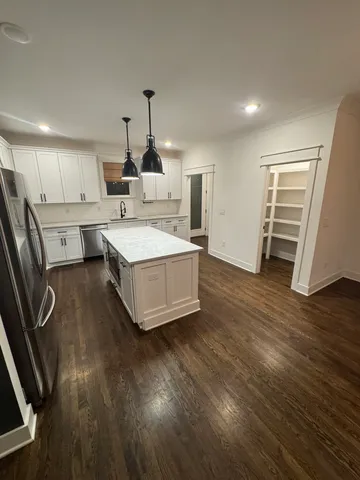 a view of an empty room with wooden floor fireplace and a window