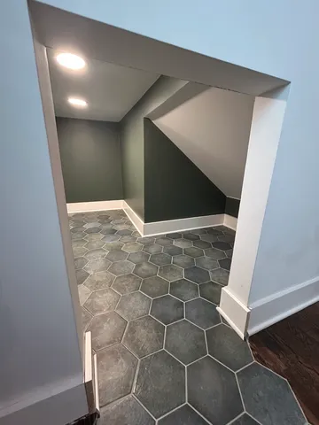 an empty room with wooden floor chandelier fan and windows