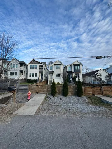 a kitchen with stainless steel appliances a sink a stove a refrigerator cabinets and wooden floor