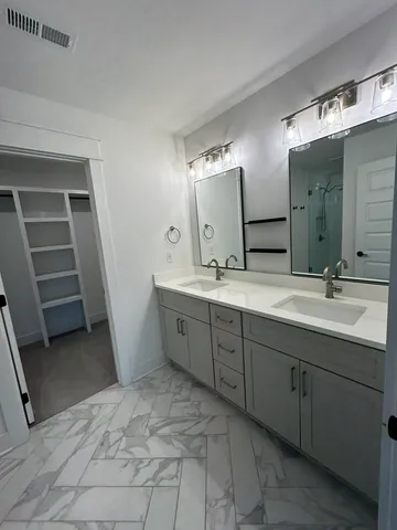 a spacious bathroom with a mirror sink and toilet