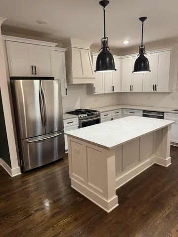 a living room with a fireplace wooden floor and a view of kitchen