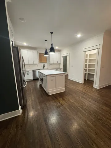 a kitchen with stainless steel appliances granite countertop a sink a stove and a wooden floor