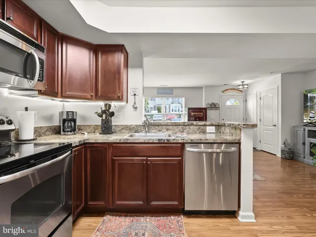 a kitchen with stainless steel appliances granite countertop a sink stove and microwave