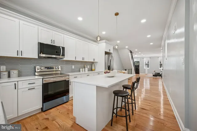 a kitchen with a sink stainless steel appliances and white cabinets