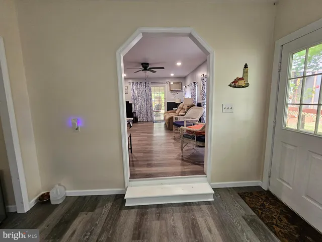 a living room with furniture a flat screen tv and a window