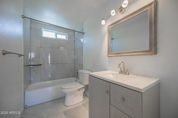 a bathroom with a sink a toilet and shower a mirror