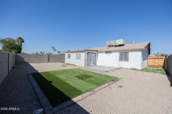 a view of a house with backyard and trees