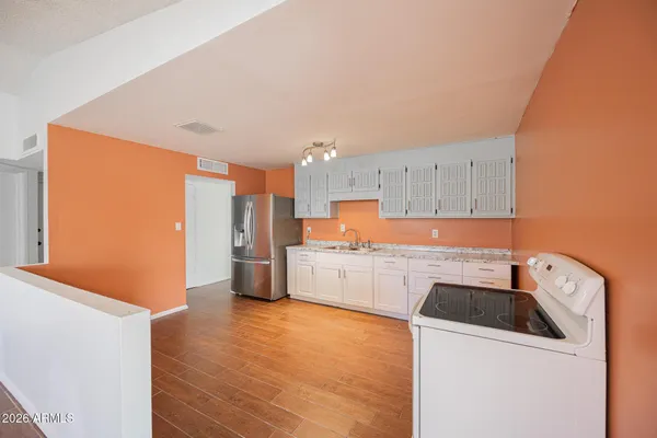 a kitchen with a refrigerator sink and cabinets