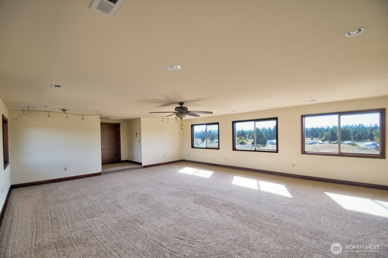 7737 Bordeaux Vista Road Southwest Olympia, WA 98512 - Photo 19 of 38 an empty room with windows and ceiling fan