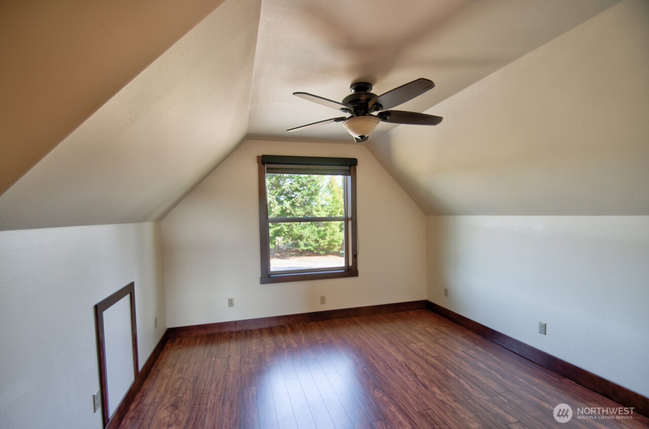 7737 Bordeaux Vista Road Southwest Olympia, WA 98512 - Photo 21 of 38 an empty room with wooden floor fan and windows