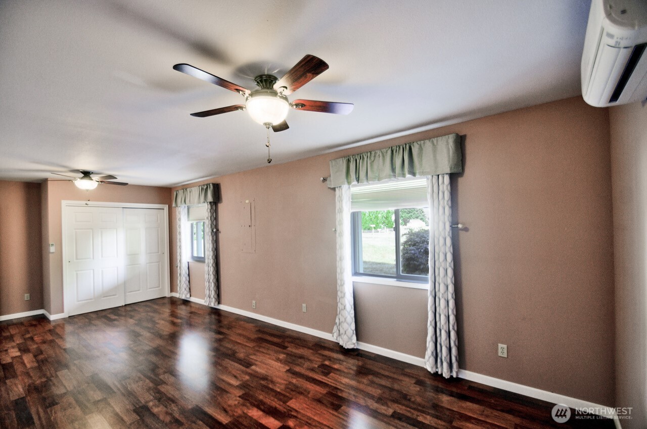 7737 Bordeaux Vista Road Southwest Olympia, WA 98512 - Photo 24 of 38 a view of an empty room with wooden floor and a window