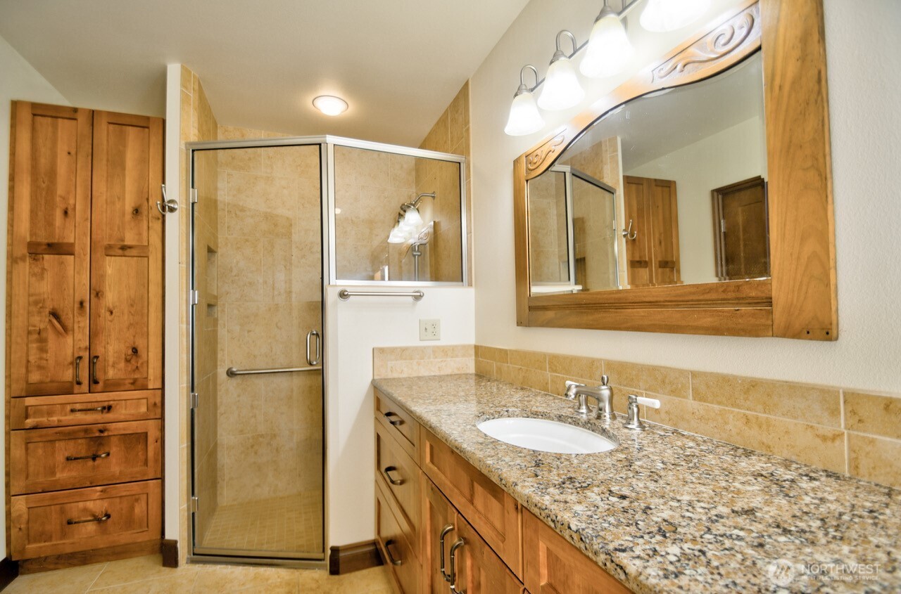 7737 Bordeaux Vista Road Southwest Olympia, WA 98512 - Photo 26 of 38 a bathroom with a granite countertop sink and a mirror